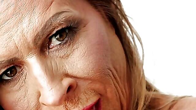 A wife and granny with big, fake tits dips deep inside her