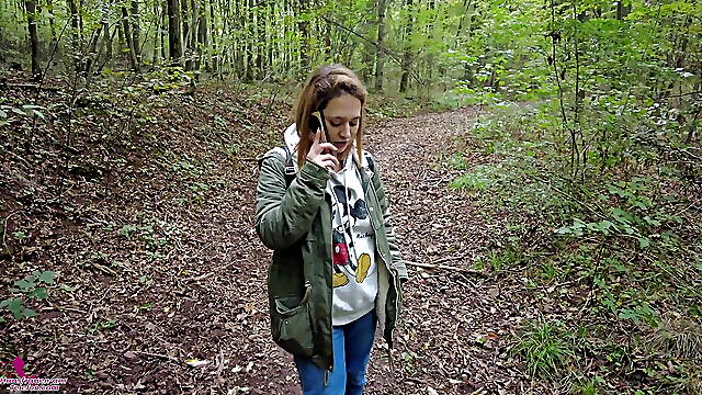 Kinky brunette strolls through woods talking on a phone and gets horny